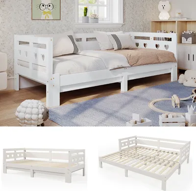 A white wooden daybed with two mattresses is set up in a child's bedroom with toys and decorations.