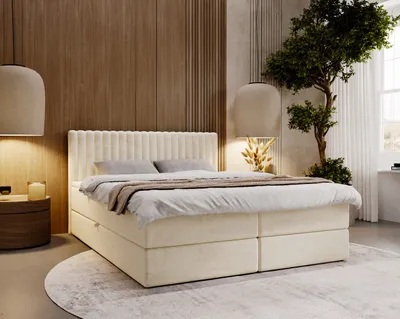 A bedroom scene featuring a boxspring bed, bedside table, and decorative elements.