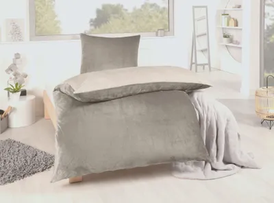 A bed with winter bedding in a room with a window.