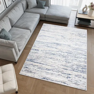 A modern living room with a sectional sofa and a rug.