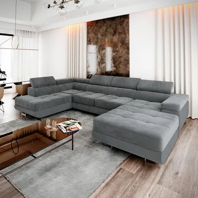 A large, sectional gray sofa in a modern living room with a coffee table in front.