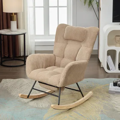 A beige corduroy rocking chair with a headrest is shown in a living room setting, next to a side table with a lamp and a window with curtains.