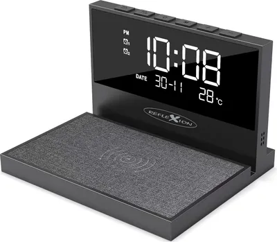 A digital clock with a wireless charging pad in the foreground, set against a white background.