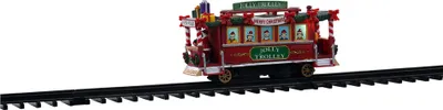 A festive red trolley decorated for Christmas, sitting on a black train track.