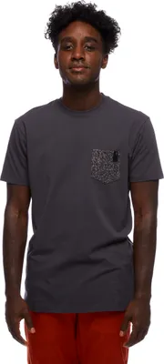 M Pocket Square Tee von Black Diamond; grau mit Brusttasche; getragen von einem jungen Mann mit lockigem Haar.