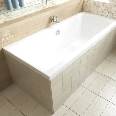 A white bathtub with beige tiled skirting and a wooden panel above, set in a bathroom.