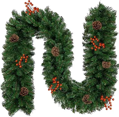 A green Christmas garland decorated with pine cones and red berries, laid out in a U-shape on a white background.