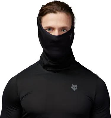 A man wearing a black long-sleeved shirt and a black neck gaiter/face mask with a Fox logo.