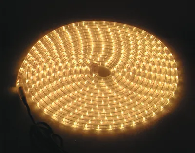 A coiled LED light strip illuminated against a dark background.