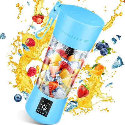 A blue portable blender filled with fruit and ice, surrounded by splashing juice and scattered fruit.