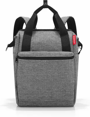 A gray backpack with black straps and zippers is shown against a white background.