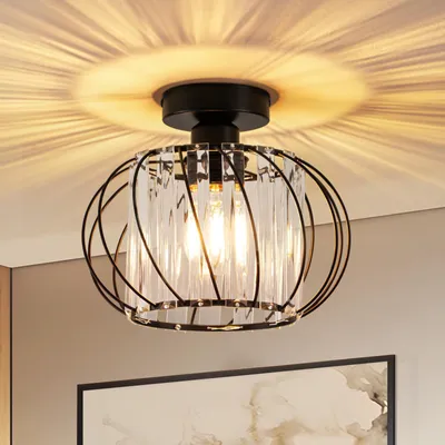 A close-up shot of a black metal and crystal ceiling light fixture, casting a patterned light on the ceiling.