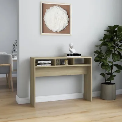 A console table with decorative items and books is placed against a wall, with a large plant to its right.