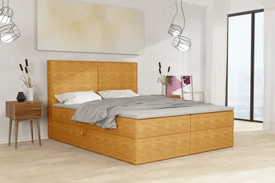 A bedroom scene featuring a large bed with bedding, a nightstand, and decorative elements.