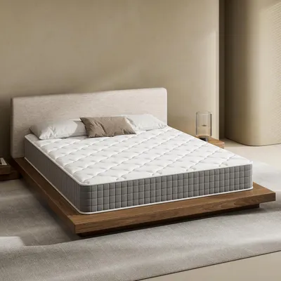 A mattress on a wooden bed frame in a minimalist bedroom setting.