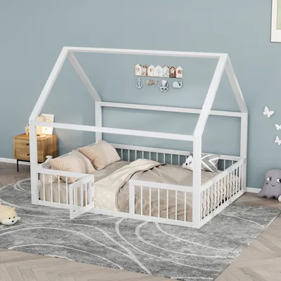 A white house-shaped bed frame with bedding and decorative items in a child's room.