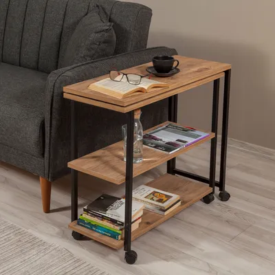 A side table next to a sofa, with books, glasses, and a cup of coffee on it.
