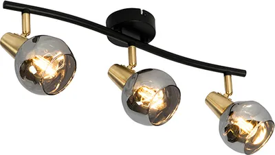A three-light track light fixture with a curved black bar and gold accents, featuring smoked glass shades.