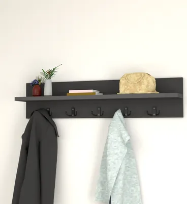 A dark gray wall-mounted shelf with hooks, holding coats, a bag, and some decorative items.
