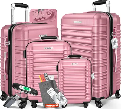 A set of four pink suitcases of varying sizes, arranged in a group. Accessories like a passport, tickets, and a luggage scale are placed in front of the suitcases.