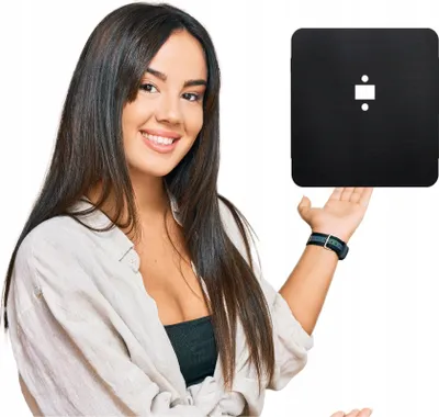 A woman is presenting a black square object.
