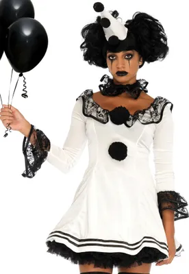 A woman dressed as a clown holding black balloons.