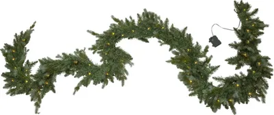 A green Christmas garland with small yellow lights and pinecones, laid out in a wavy shape on a white background.