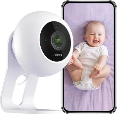A baby monitor camera is shown next to a smartphone displaying a live feed of a baby.