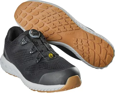 A pair of black safety shoes with a white sole and brown accents, shown from a slightly elevated angle. One shoe is upright, and the other is lying on its side, revealing the sole.