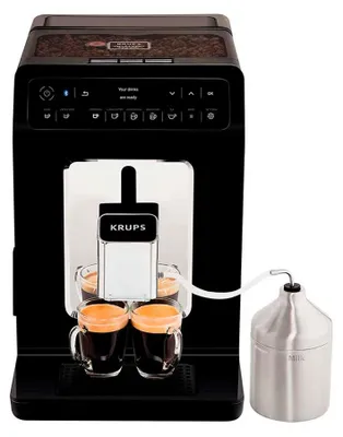 A black Krups espresso machine with two cups of espresso and a milk container.