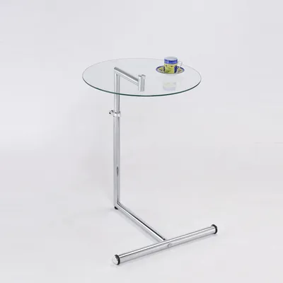 A modern glass and chrome side table with a cup on it.