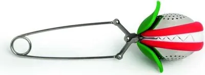 A tea infuser shaped like a flower or fruit, with a metallic body and red and green accents, attached to a metal handle with a ring.