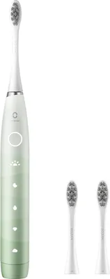 A white electric toothbrush with green accents and two replacement brush heads on a white background.