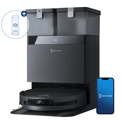 A robotic vacuum cleaner with its charging and cleaning station, a bottle of cleaning fluid, and a smartphone displaying the brand's app.