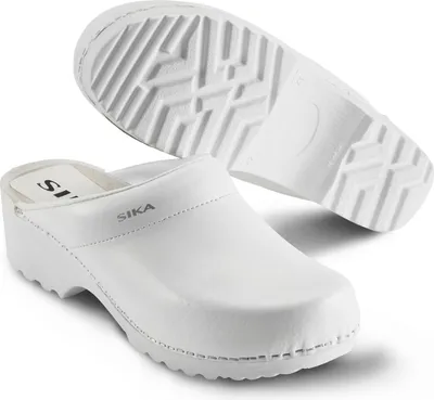 A pair of white Sika clogs are shown against a white background. One clog is in the foreground, and the sole of another clog is visible in the background.