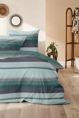 A neatly made bed with striped bedding in a room with decorative elements.