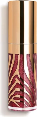 A close-up shot of a cosmetic product with a gold cap and a red and gold zebra print design on the body.