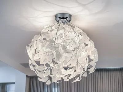 A decorative LED ceiling light with a leaf-shaped lampshade is mounted on a white ceiling.