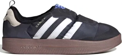 A side view of a black Adidas Puffylette sneaker with white stripes and a brown sole.