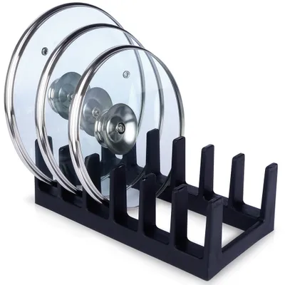 A black pot lid organizer holding three glass pot lids.