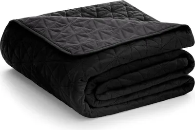 A folded black quilted blanket on a white background.