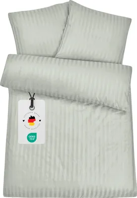 A folded duvet cover and two pillowcases are laid out on a white background. A tag is attached to the duvet cover.