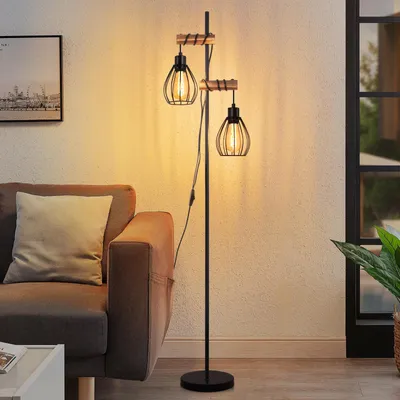 A floor lamp with two lights is placed next to a sofa in a living room.