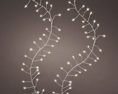 Two strands of white LED lights with thin branches against a gray background.