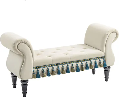 A beige upholstered bench with rolled arms and decorative tassels.