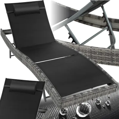 A rattan sun lounger with a black cushion and headrest, shown from a slightly elevated diagonal angle.