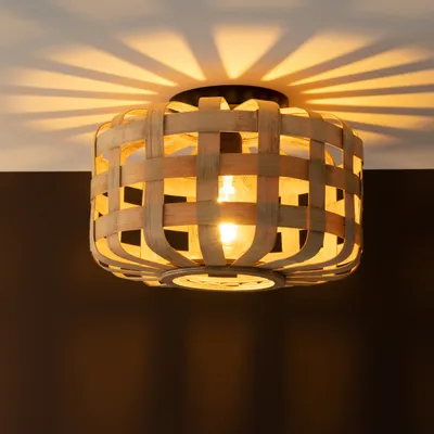 A close-up shot of a bamboo ceiling lamp with a woven design, casting shadows on the ceiling.