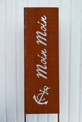 A rusty metal sign with the text "Moin Moin" and an anchor symbol.