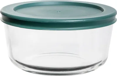 A clear glass food storage container with a green lid.