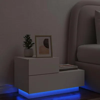 A white nightstand with LED lighting is shown next to a bed.